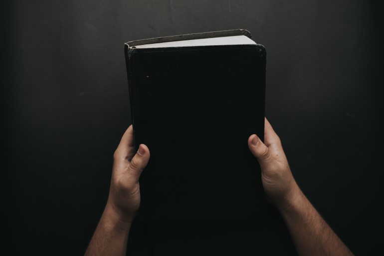 person-holding-black-cover-bible-2258240
